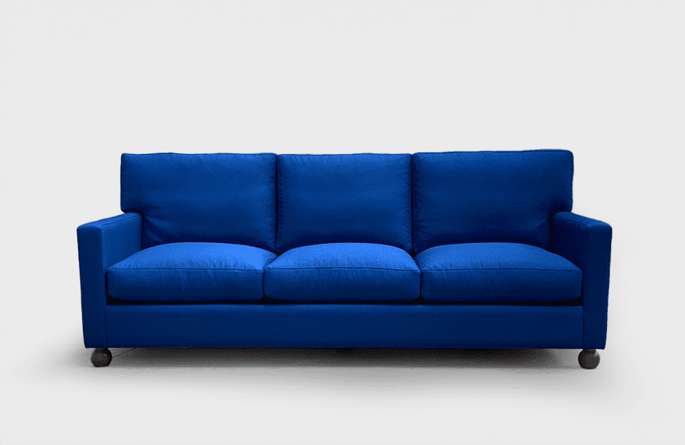 Soffan Karin är en modern klassiker med klotformade ben och härlig komfort. En mycket bekväm 3-sitssoffa med sköna lösa dunplymåer i både rygg och sits. Klädd i ett blått tyg.